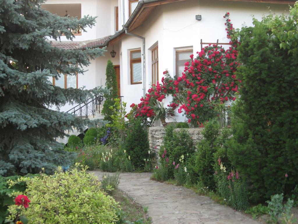 een tuin voor een huis met bloemen bij Guest House Astra in Arbanasi