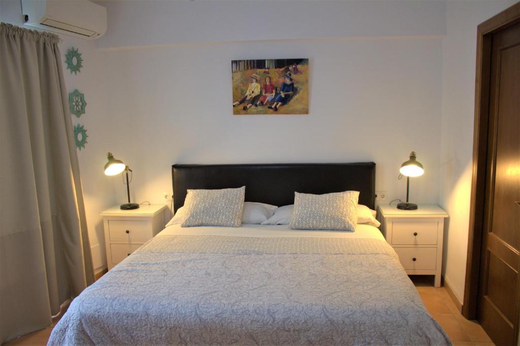 1 dormitorio con 1 cama grande y 2 mesitas de noche en Hostal Don Peque Adult Recommended, en Nerja