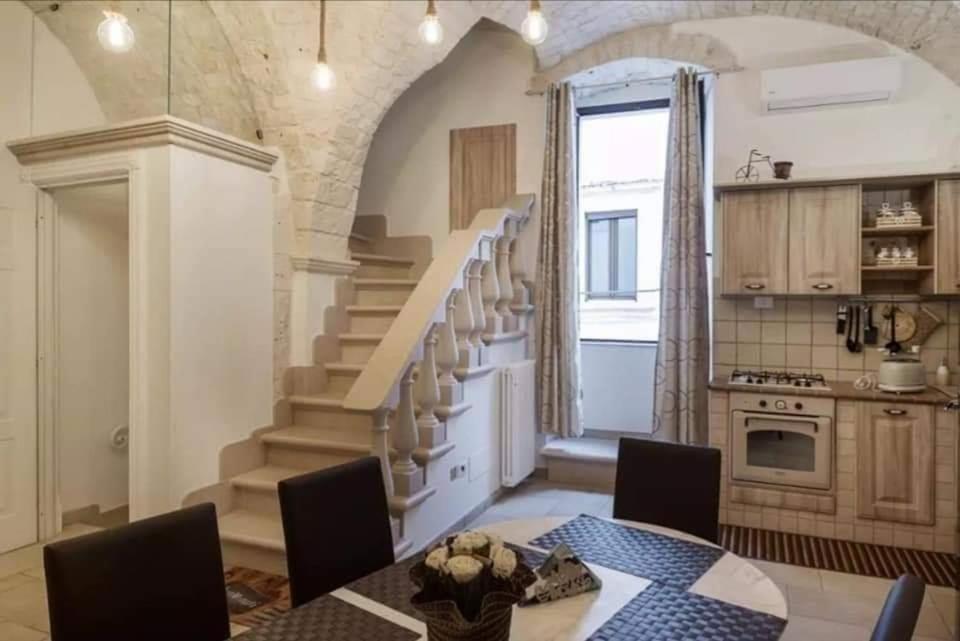 une cuisine avec un escalier, une table et des chaises dans l'établissement CASA VACANZE IL RIFUGIO DEL PRINCIPE 2, à Putignano