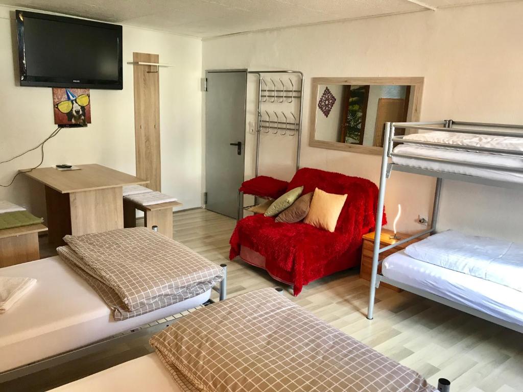a room with two bunk beds and a red couch at Ferienwohnung in Ediger Eller in Ediger-Eller