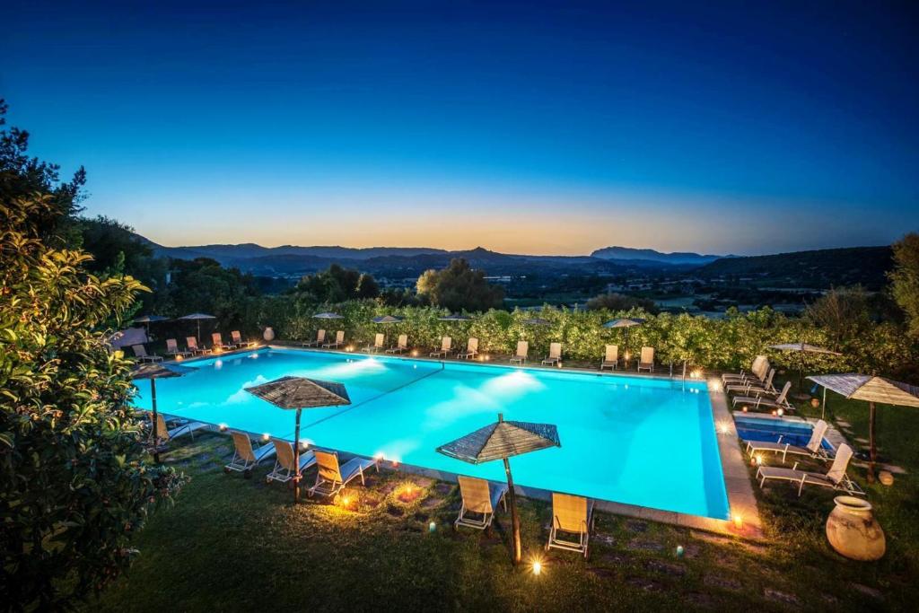 an image of a pool at night with umbrellas at Su Gologone in Oliena