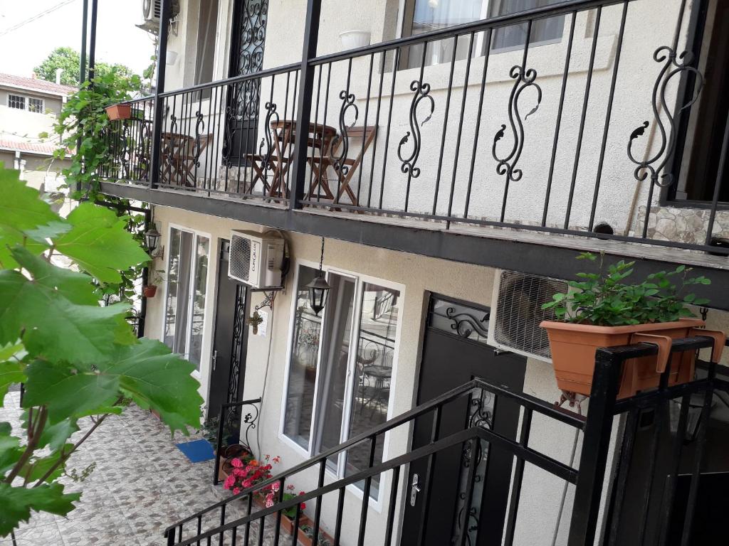 uma varanda de uma casa com vasos de plantas sobre ela em GTNL Aparthotel em Tbilisi