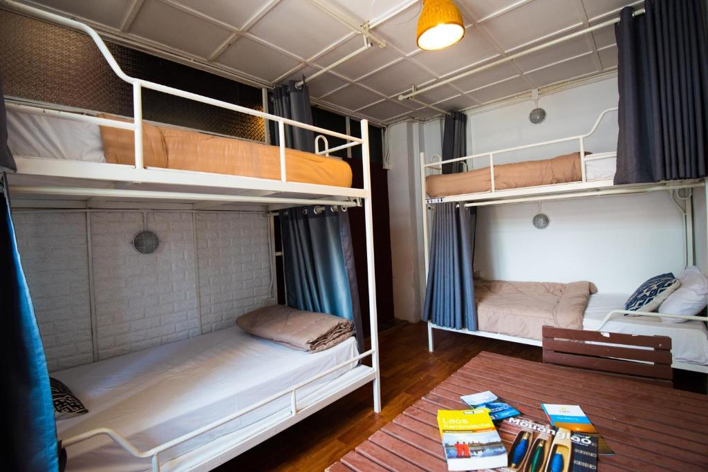 two bunk beds in a room with a table at 1918’s HOSTEL in Pakse