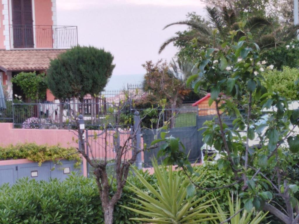 un giardino di fronte a una casa con l'oceano sullo sfondo di La Casa di Sandra a Porto Potenza Picena