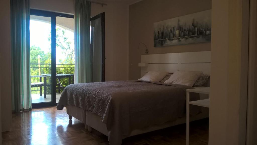 1 dormitorio con 1 cama y puerta corredera de cristal en Rooms and Apartments Mofardin, en Rovinj