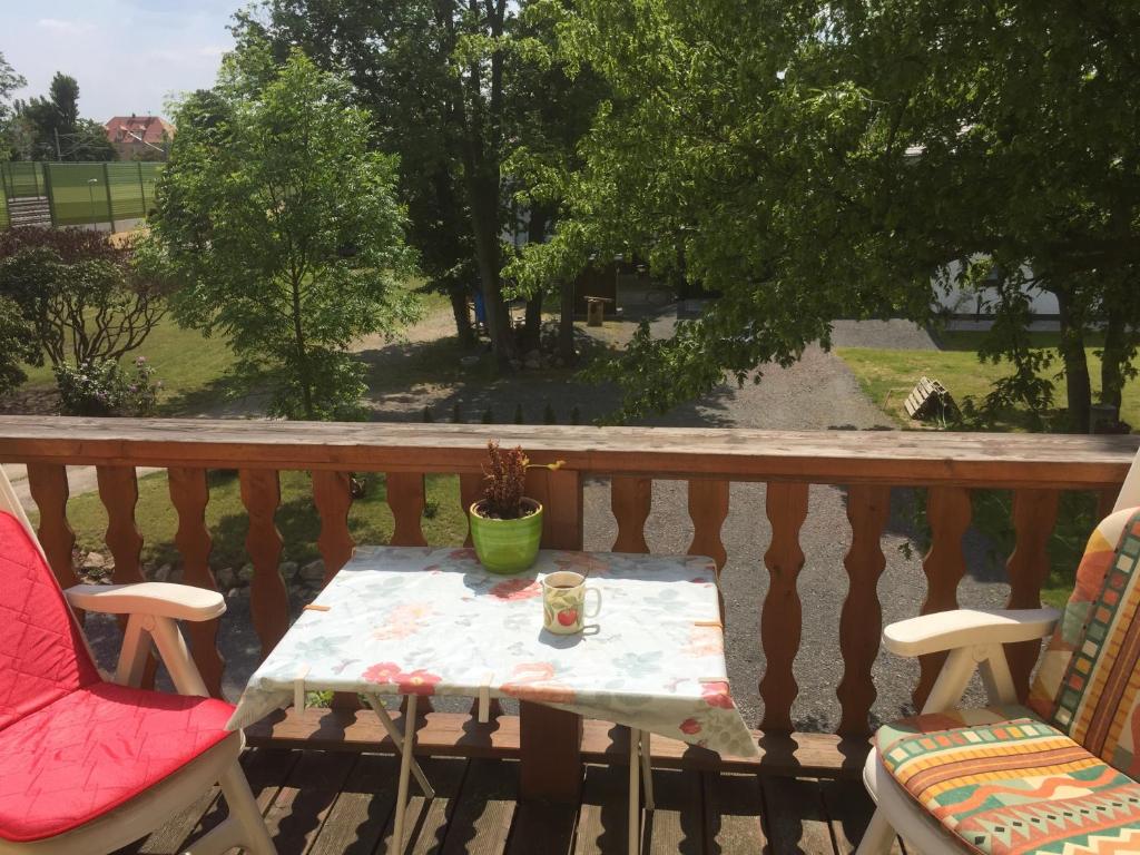 a table and chairs on a balcony with a cup of coffee at Gertrud in Gaschwitz