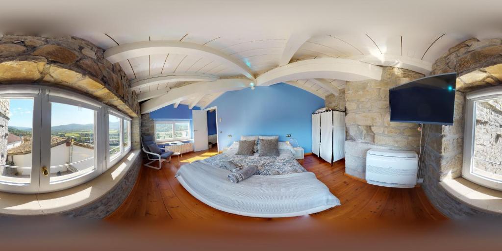 sypialnia z łóżkiem w pokoju z dużymi oknami w obiekcie Apartamentos Turisticos Graus w mieście Graus
