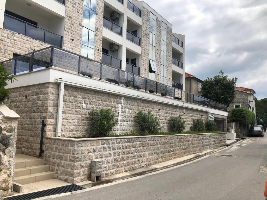 budynek apartamentowy ze ścianą z cegły w obiekcie Apartments Bane w mieście Herceg Novi