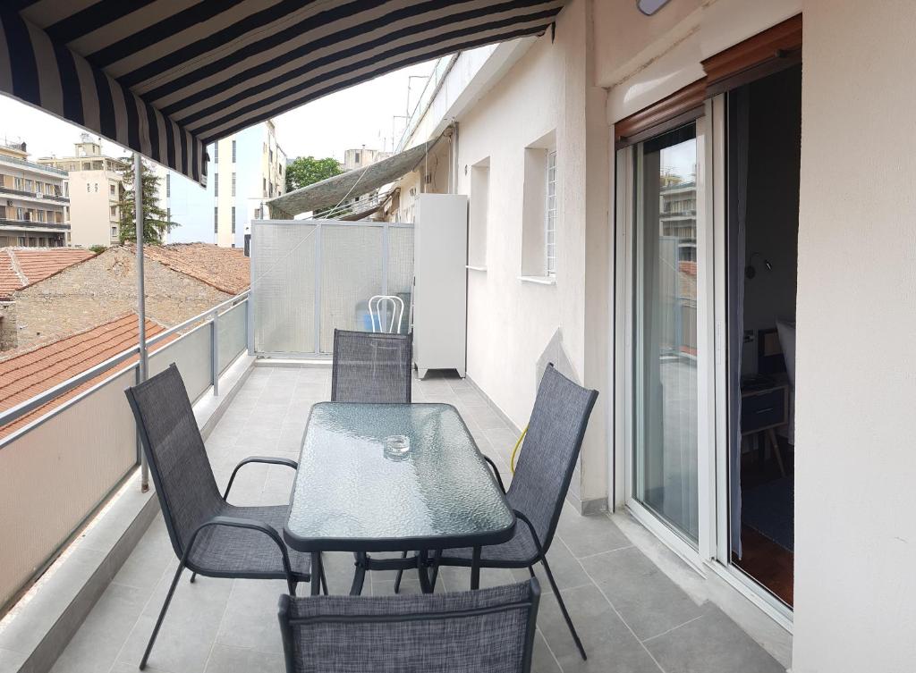 patio ze stołem i krzesłami na balkonie w obiekcie MAHE APARTMENT w mieście Wolos