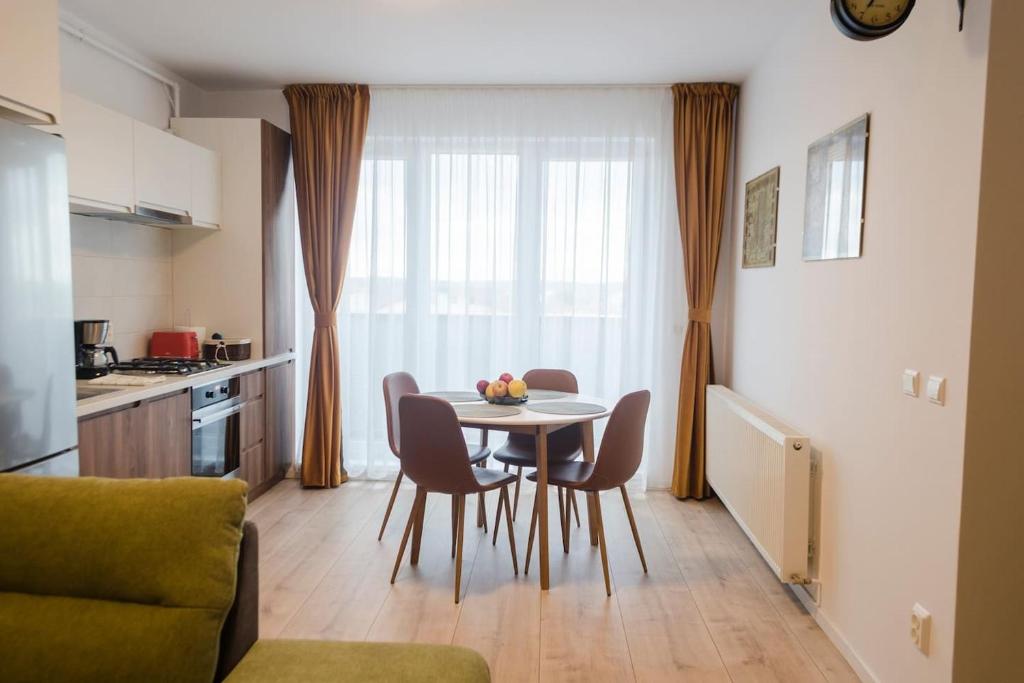 a kitchen with a table and chairs in a room at Paul's place. New rooftop apartment in Downtown Sibiu in Sibiu
