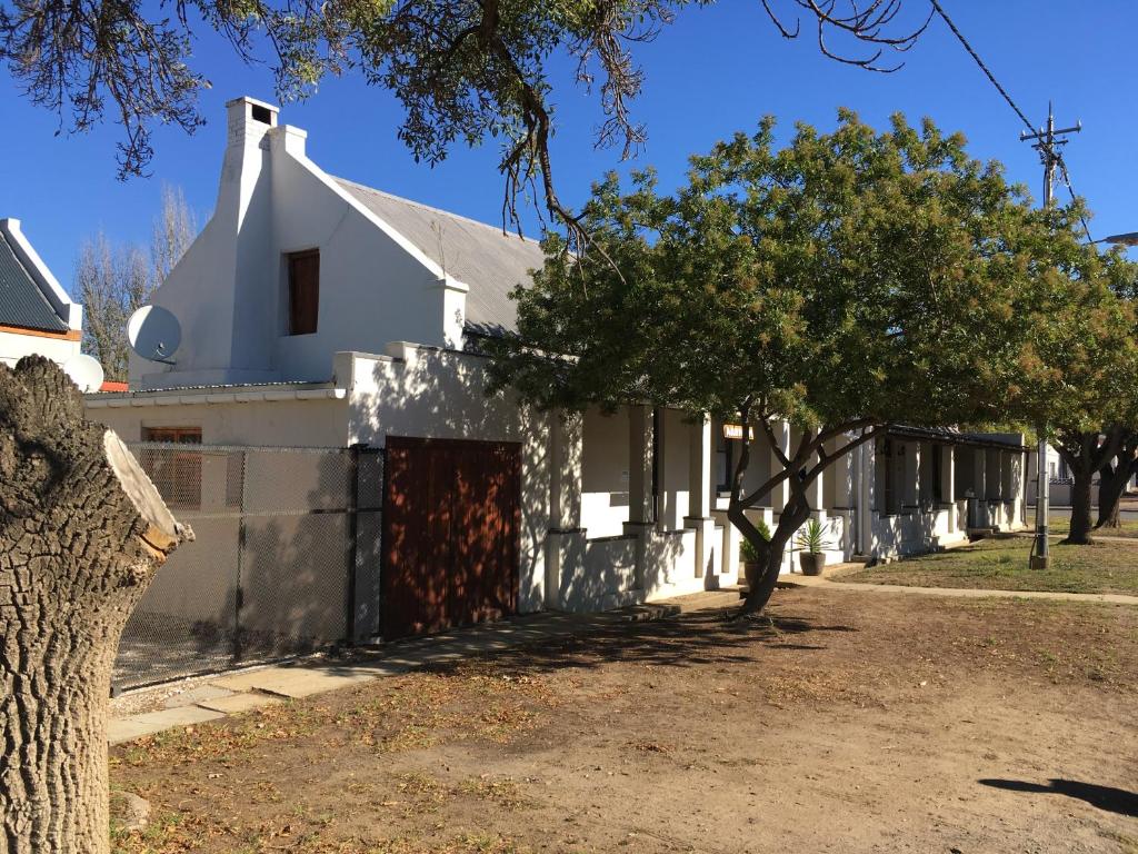 a white house with trees in front of it at Arnheim Guesthouse in Robertson