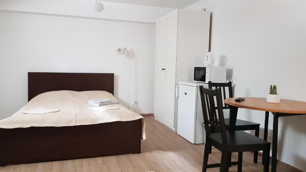 a bedroom with a bed and a table and a microwave at SAULES SVECIU NAMAI in Palanga
