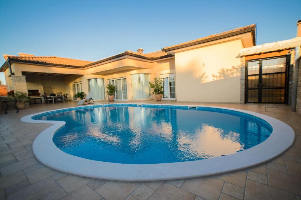 a swimming pool in front of a house at Villa Vacanza in Međugorje