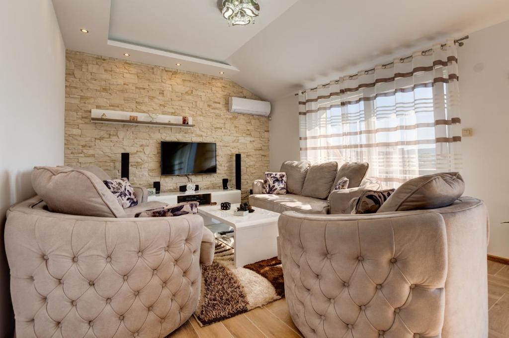 a living room with two chairs and a couch at DiVino Apartment in Tivat