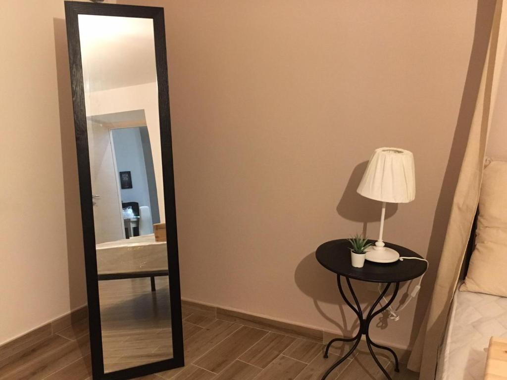 1 dormitorio con espejo y mesa con lámpara en IL PANARO en Palermo