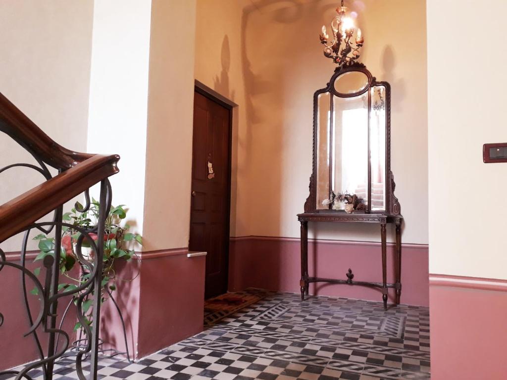 un couloir avec un escalier et un miroir sur une table dans l'établissement Soffitto Dipinto, à Moncalvo
