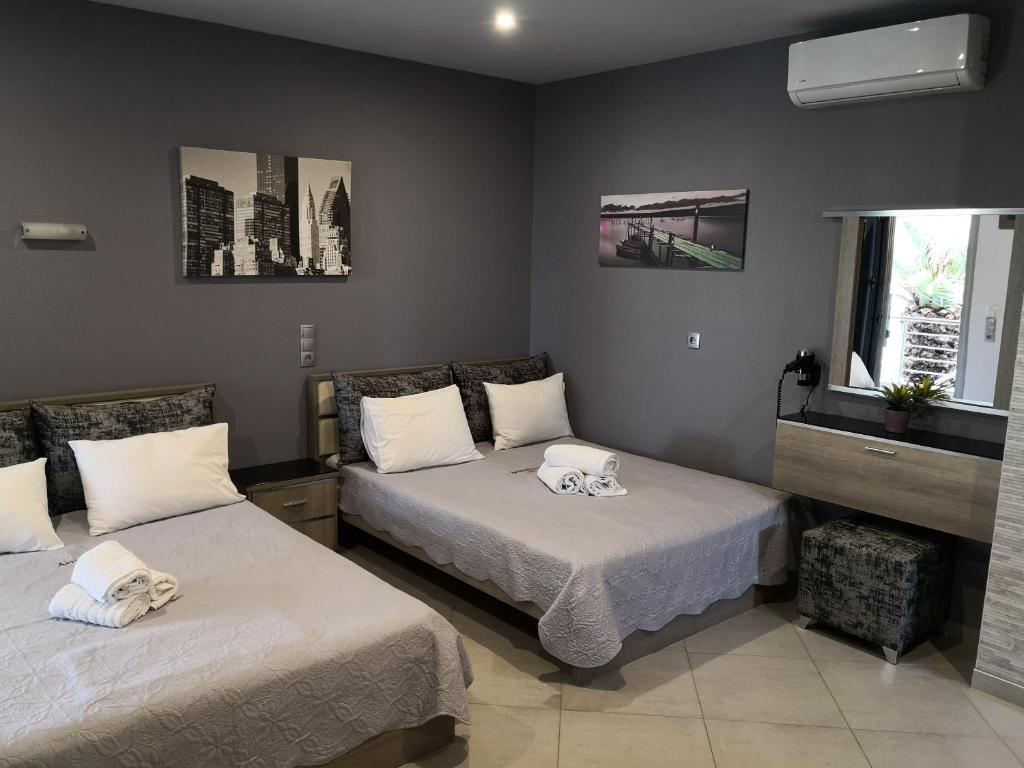 a bedroom with two beds and a window at Aimilias Family Apartments in Nea Vrasna