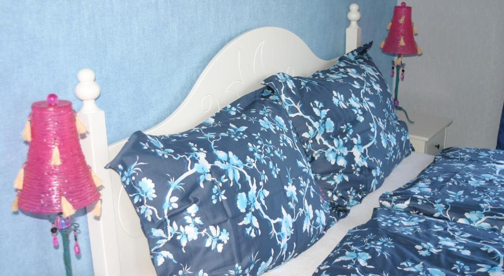 a bedroom with a bed with blue and white pillows at Appartementhaus Das Mittelpunkt in Mörbisch am See