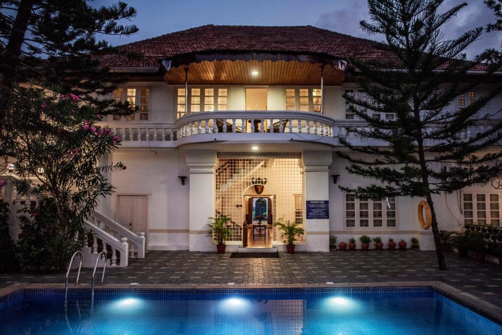 una casa con piscina frente a ella en Dutch Bungalow en Kochi