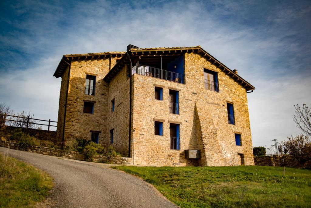 a large brick building with a balcony on a road at CASA BERNAT in Aren