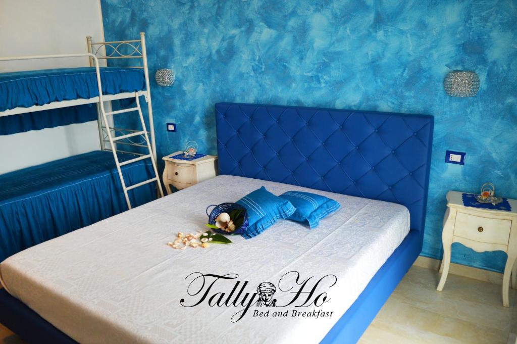un bambino sdraiato su un letto in una camera blu di Tally B&B a Salve