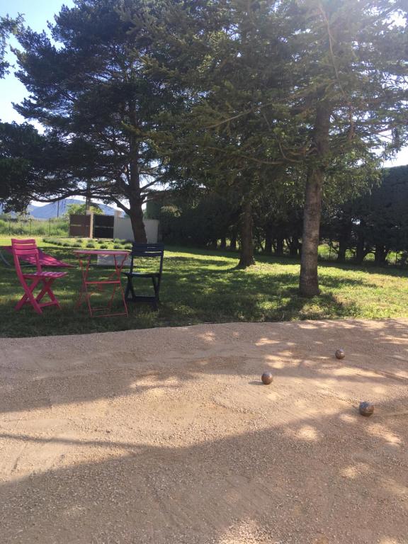 une table de pique-nique et des bancs dans un parc arboré dans l'établissement Villa Domélia, à Villelaure