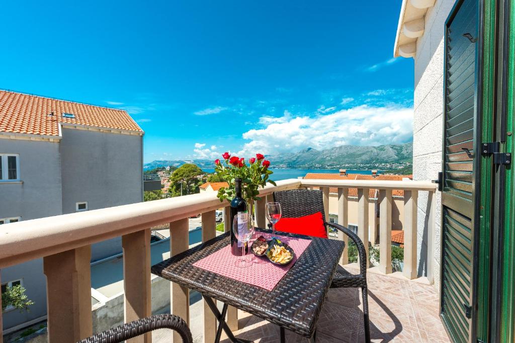 a table with a vase of flowers on a balcony at Cina Apartments in Cavtat
