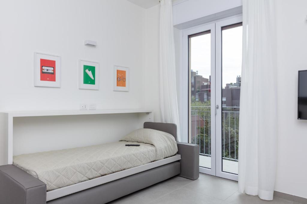 Łóżko lub łóżka w pokoju w obiekcie Cirene Apartments Milano