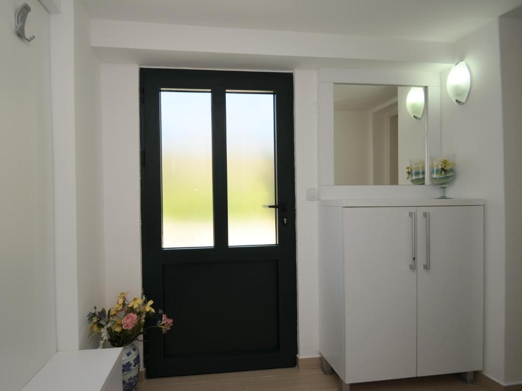 uma porta preta num quarto branco com um espelho em Apartments Kordić em Kotor