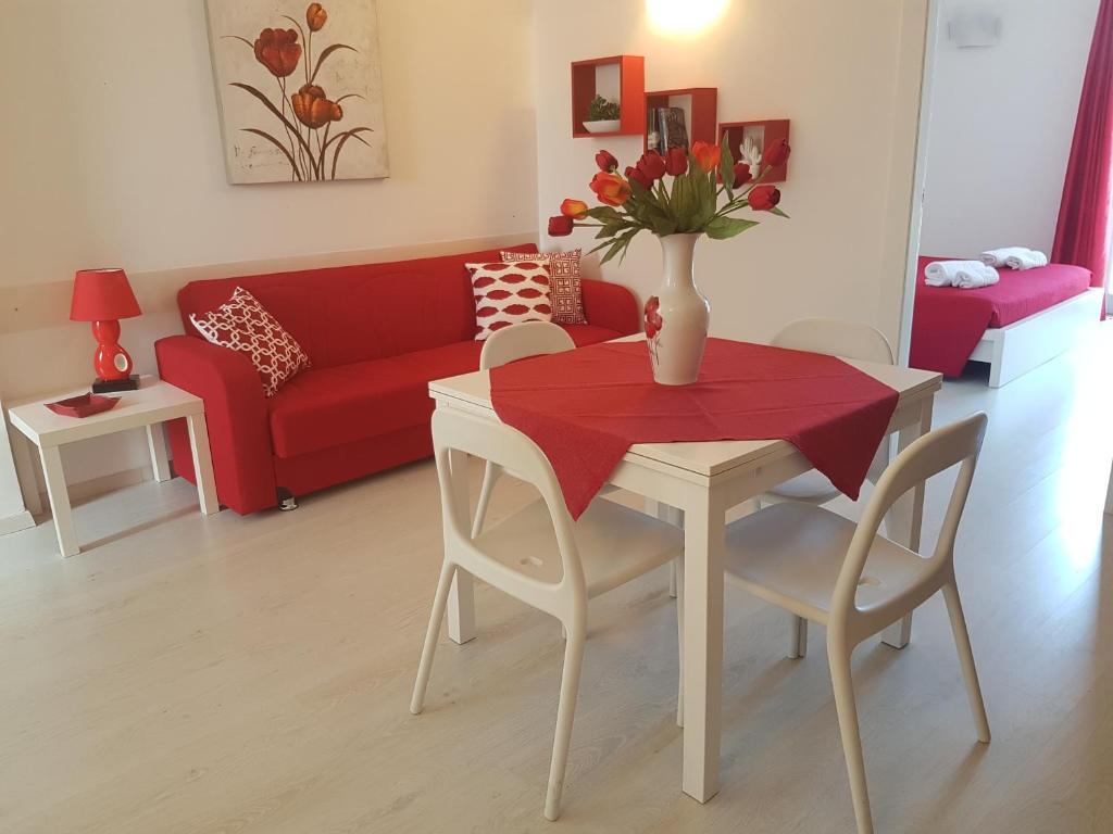 a living room with a table and a red couch at La Casa di Charme in Ragusa