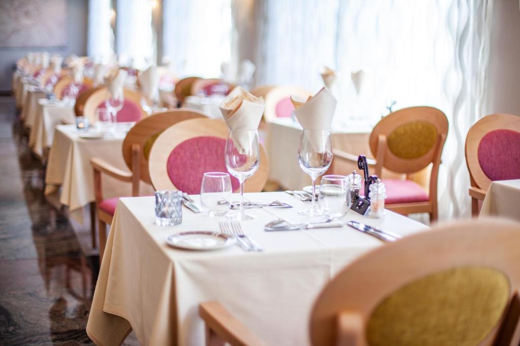 a row of tables in a restaurant with white table cloth at Grupotel Parc Natural & Spa in Playa de Muro