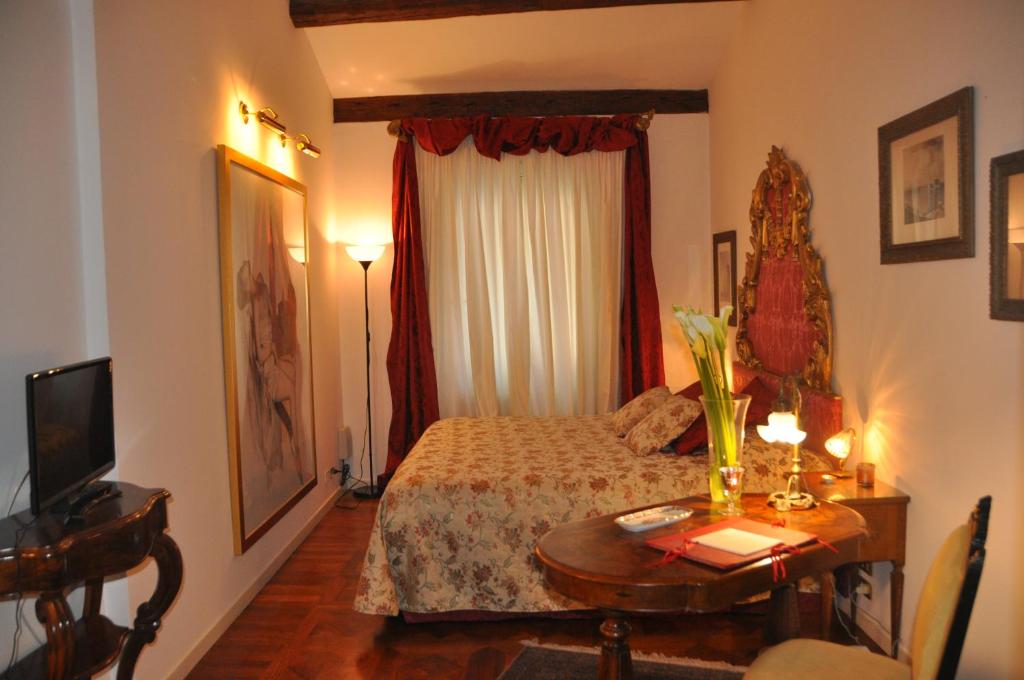 um quarto de hotel com uma cama e uma mesa com uma mesa sidx sidx em Henry's Heaven Apartment em Veneza