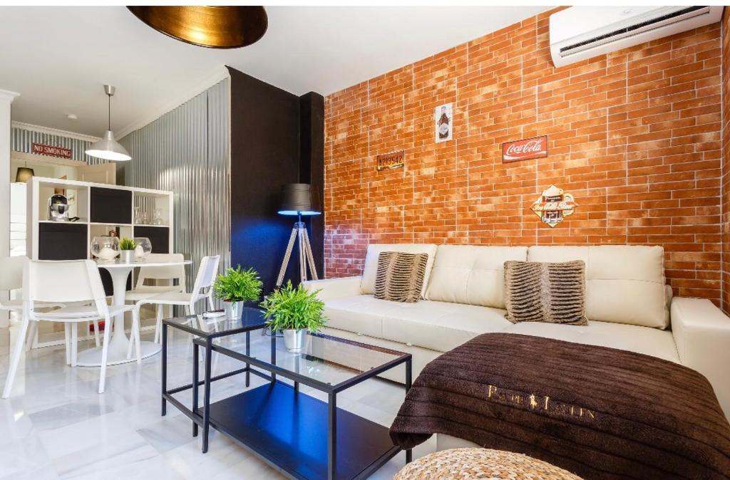 sala de estar con sofá blanco y pared de ladrillo en Apartamento semi-industrial palacio Castilla, en Jerez de la Frontera