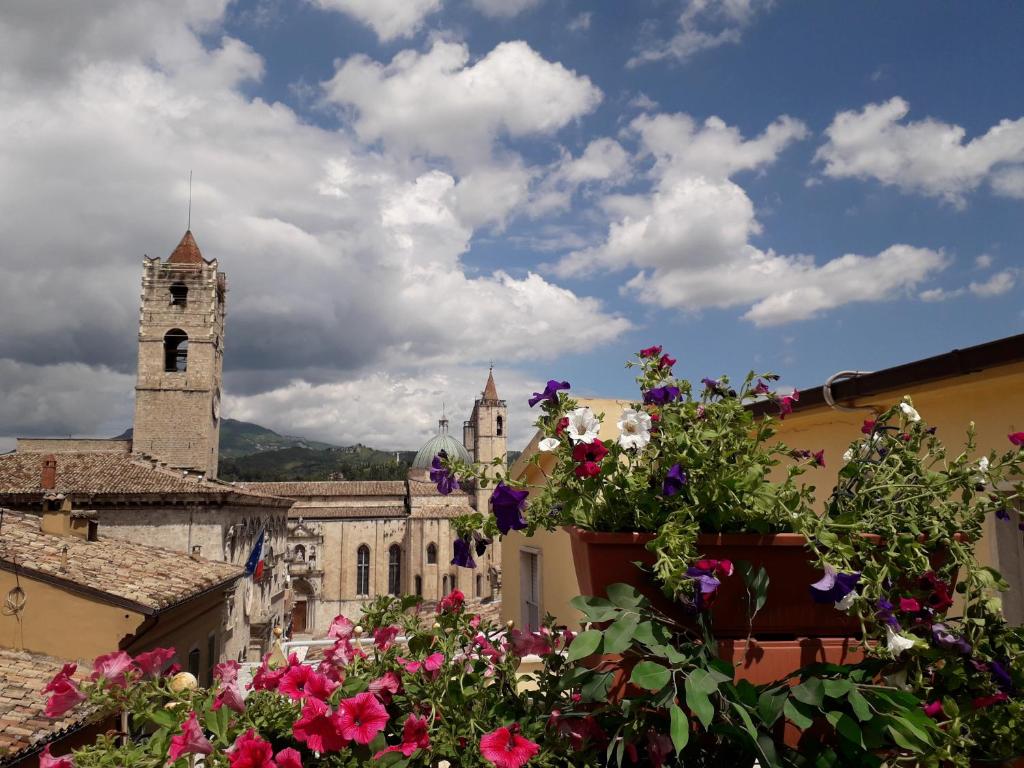 una vista de una iglesia con una torre de reloj y flores en L'Attichetto, en Ascoli Piceno