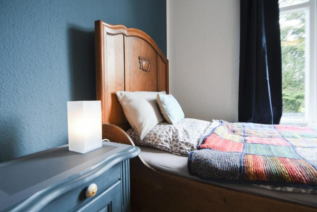 a bedroom with a bed with a lamp on a dresser at Stadtvilla Stöhr in Norden