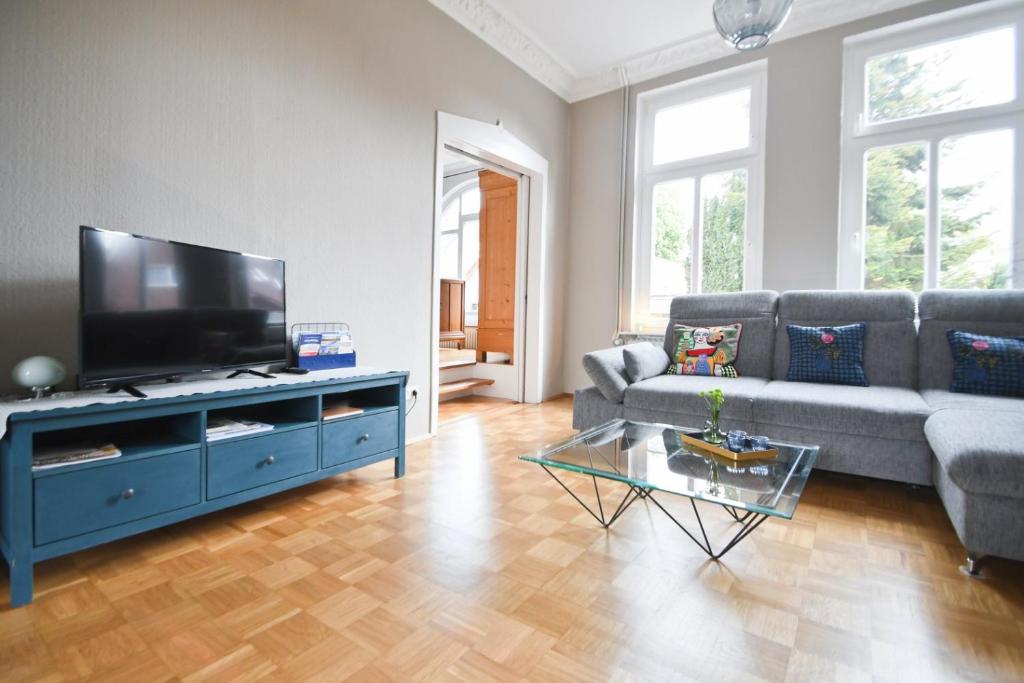 a living room with a couch and a flat screen tv at Stadtvilla Stöhr in Norden