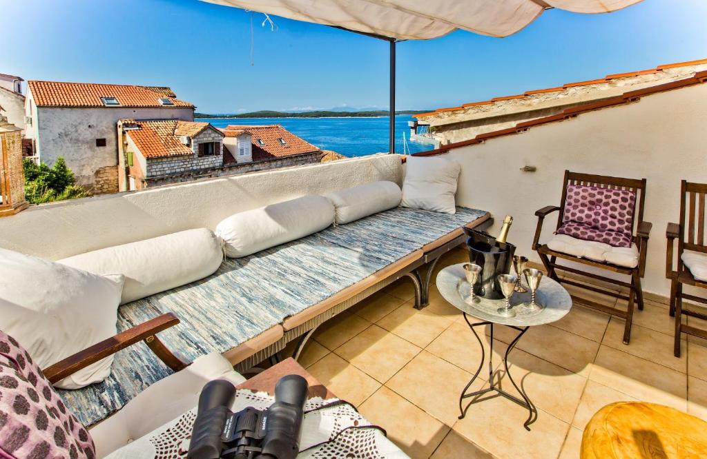 un sofá en un balcón con vistas al océano en Villa Sunce, en Hvar