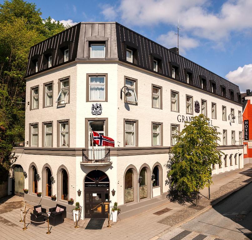 ein großes weißes Gebäude mit einer Uhr drauf in der Unterkunft Grand Hotel Arendal - Unike Hoteller in Arendal