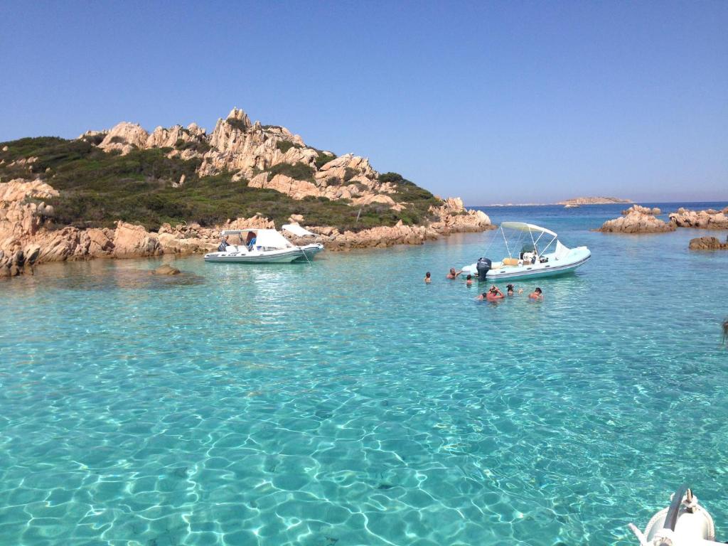 Due barche in un bacino d'acqua con dentro delle persone. di La Casa azzurra a La Maddalena