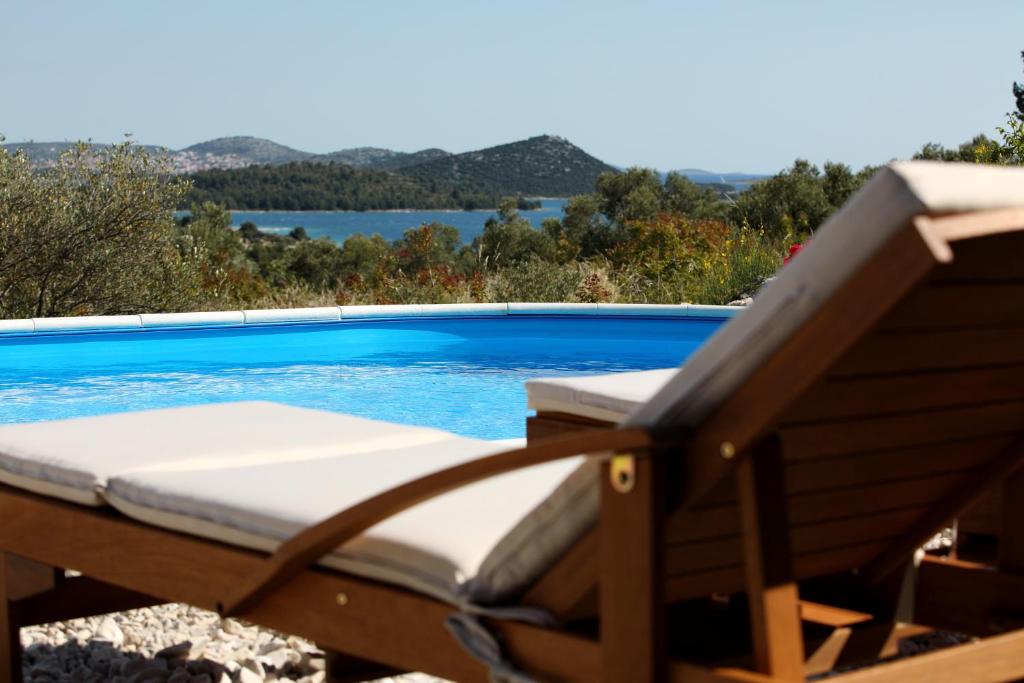 a swimming pool with a chaise lounge in front of a swimming pool at Holiday Home Petar in Drage