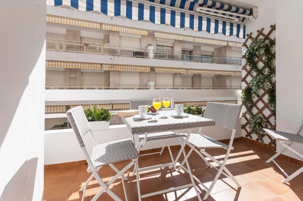 a table and chairs on a balcony with a building at Lets Holidays RENOVATED APARTMENT NEAR BEACH in Tossa de Mar