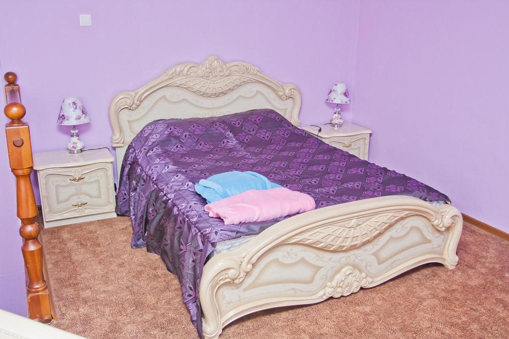 Un dormitorio con una cama con sábanas y almohadas púrpuras. en Grand City Hotel, en Chita