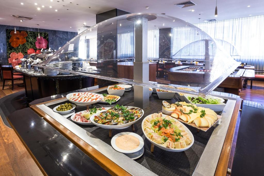 A bright buffet counter displays salads, cold cuts, seafood and fruit.