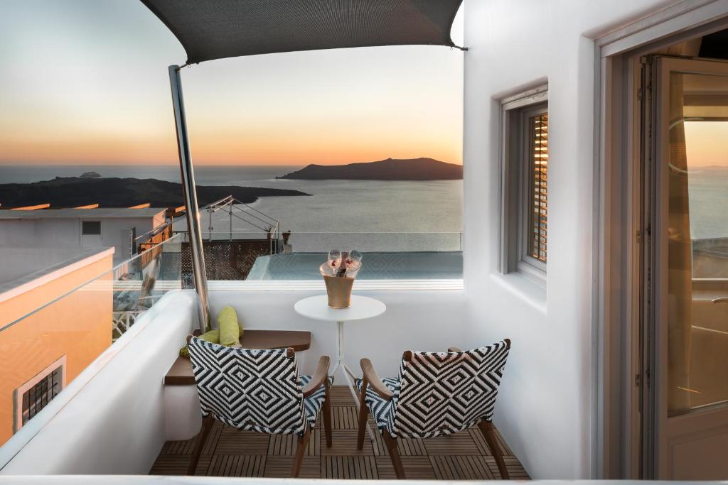 Emfasis Luxury Villa في فيرا: شرفة مع طاولة وإطلالة على المحيط