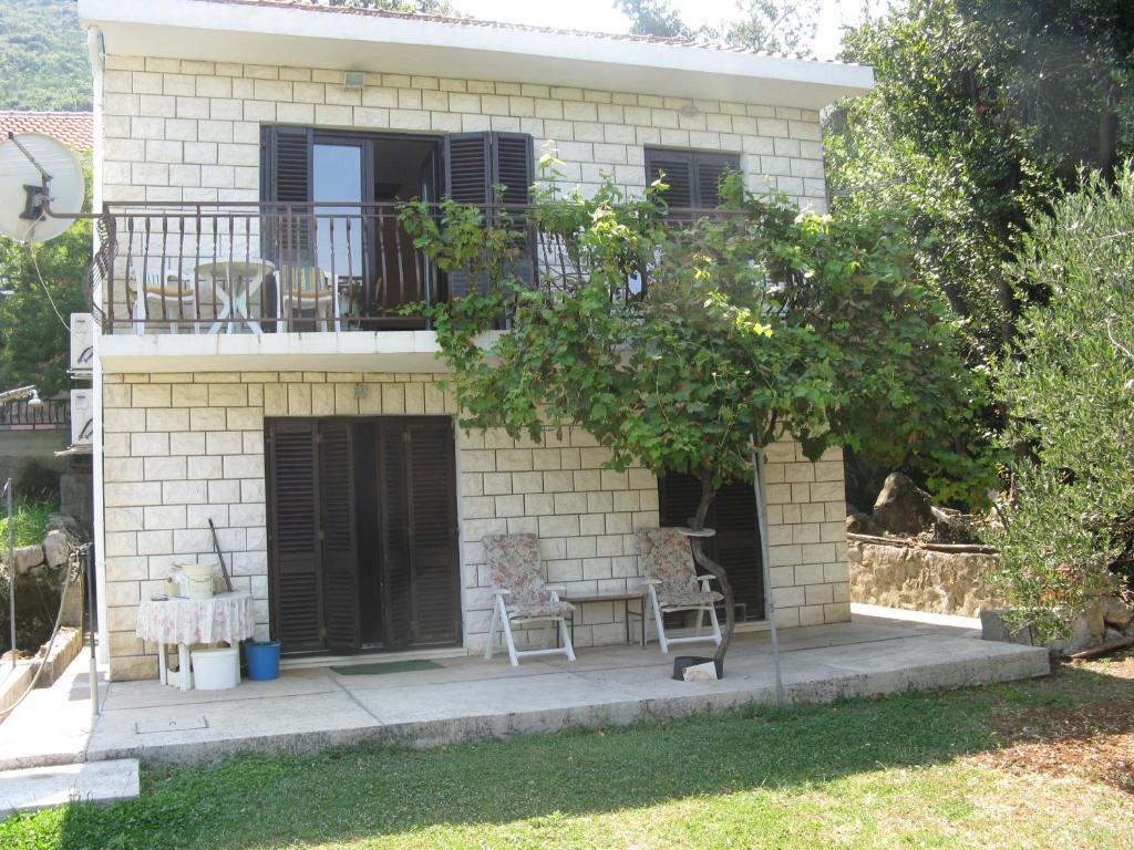a house with two chairs and a balcony at Vila Ruža in Ston