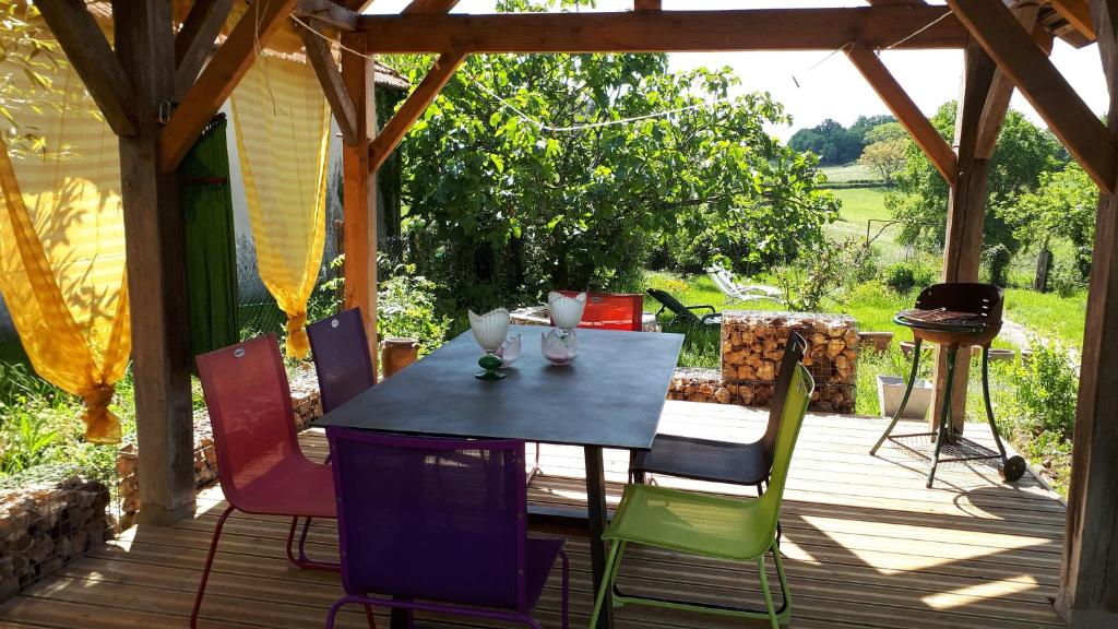 une table et des chaises sur une terrasse en bois dans l'établissement Château de l Herm, Lascaux, Sarlat, en Périgord Noir, à Rouffignac-Saint-Cernin-de-Reilhac