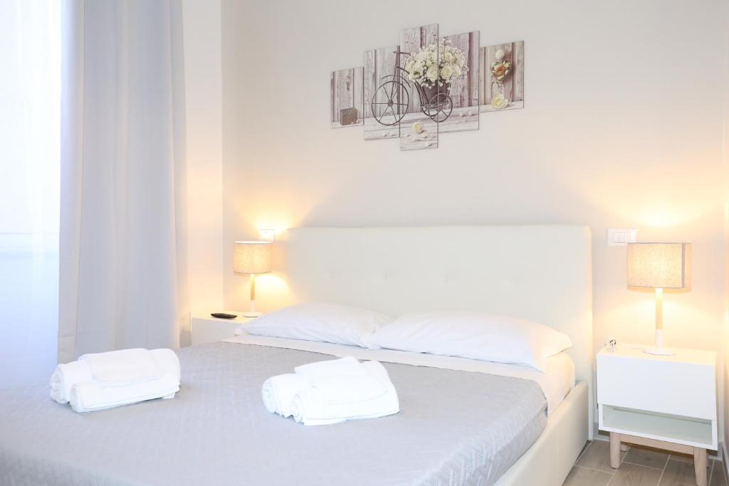a white bedroom with a bed with two towels on it at Unique luxury apartment and rooms in Rome