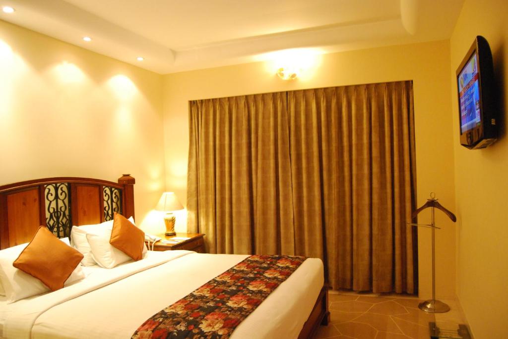 a hotel room with a bed and a television at Beverly Hotel in Chennai