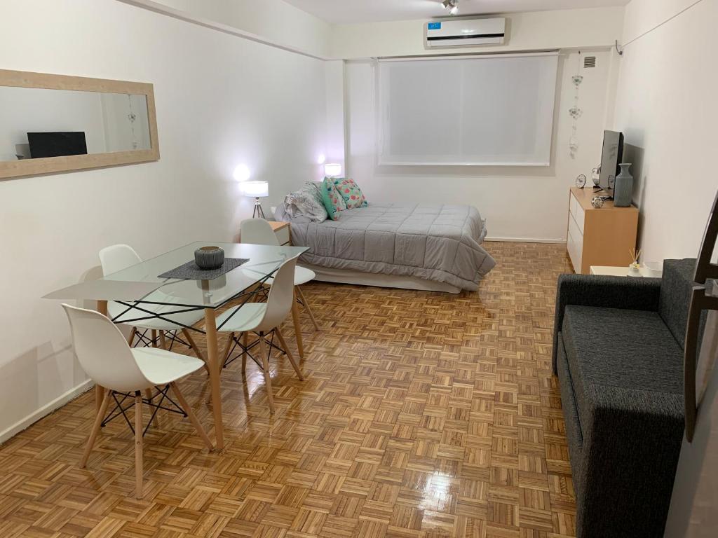 ein Wohnzimmer mit einem Bett, einem Tisch und einem Sofa in der Unterkunft Espectacular y moderno Departamento en la City porteña in Buenos Aires