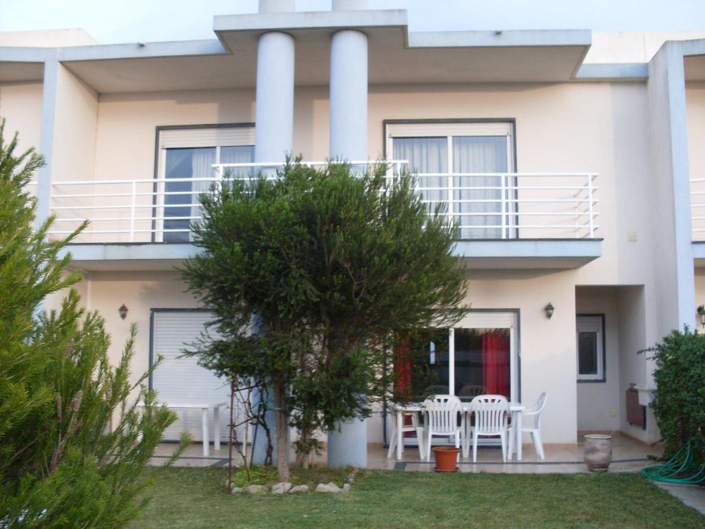 een huis met een balkon en een tafel en stoelen bij SEALOVERS in Lourinhã